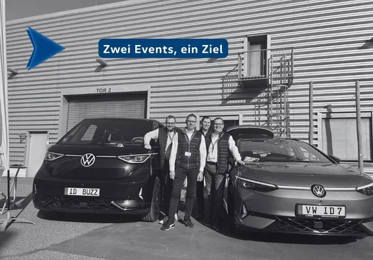 schwarz weiĂ zwischen zwei Autos stehen Personen im Hintergrund geriffelte Wand